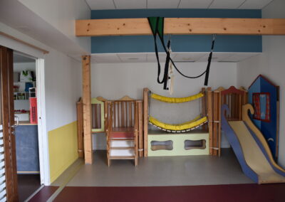 Salle de motricité de la crèche Franco-Allemande Hansel et Gretel de Nantes. Elle est équipée d'une balançoire, d'un parcours avec tobogan, des tapis et une piscine à balles.